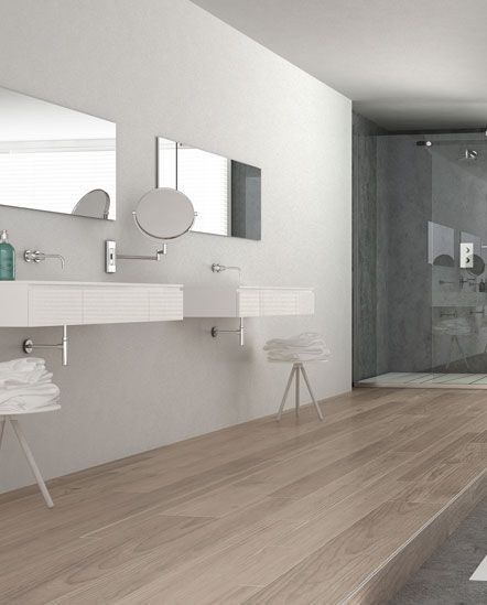 A bathroom with two sinks , a mirror and a walk in shower.