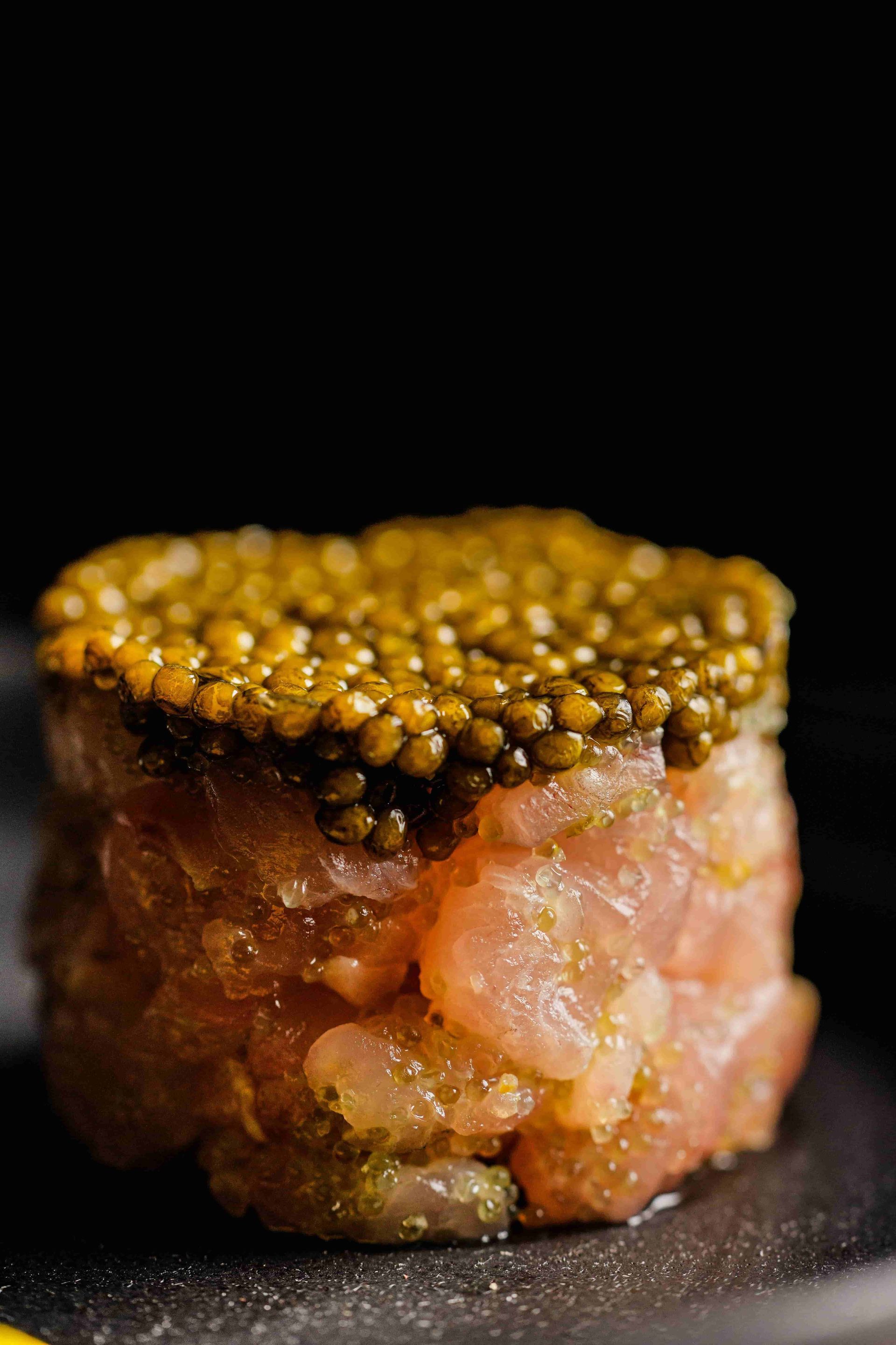 Piece of sushi fish topped with fish eggs