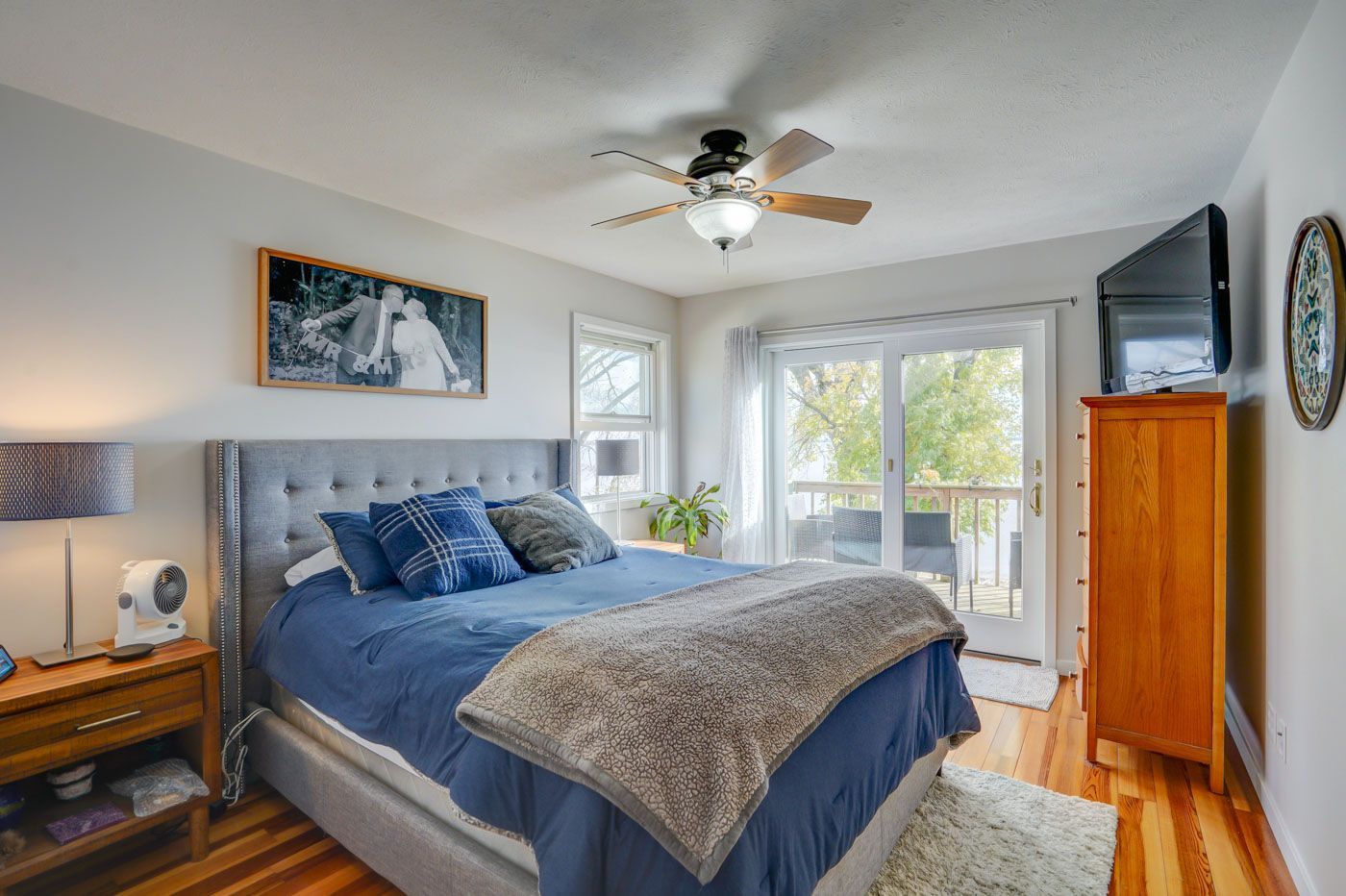 A bedroom with a large bed and a ceiling fan.
