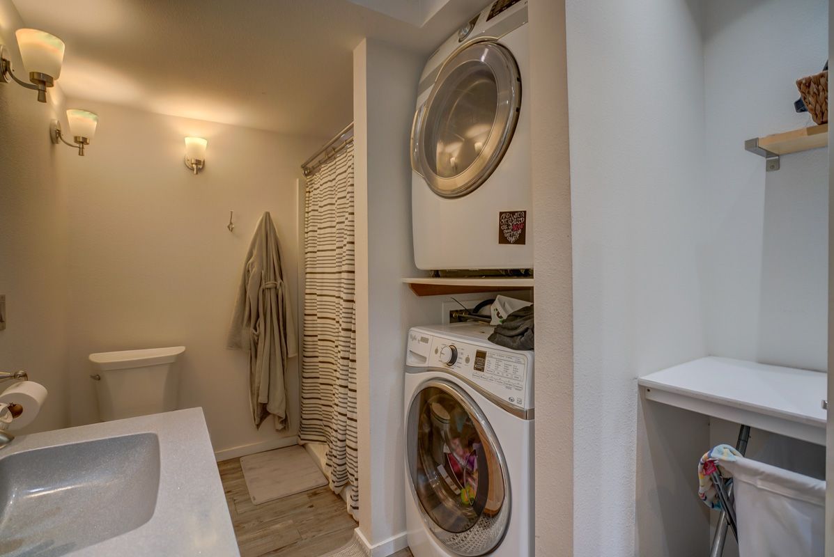 A bathroom with a washer and dryer stacked on top of each other.