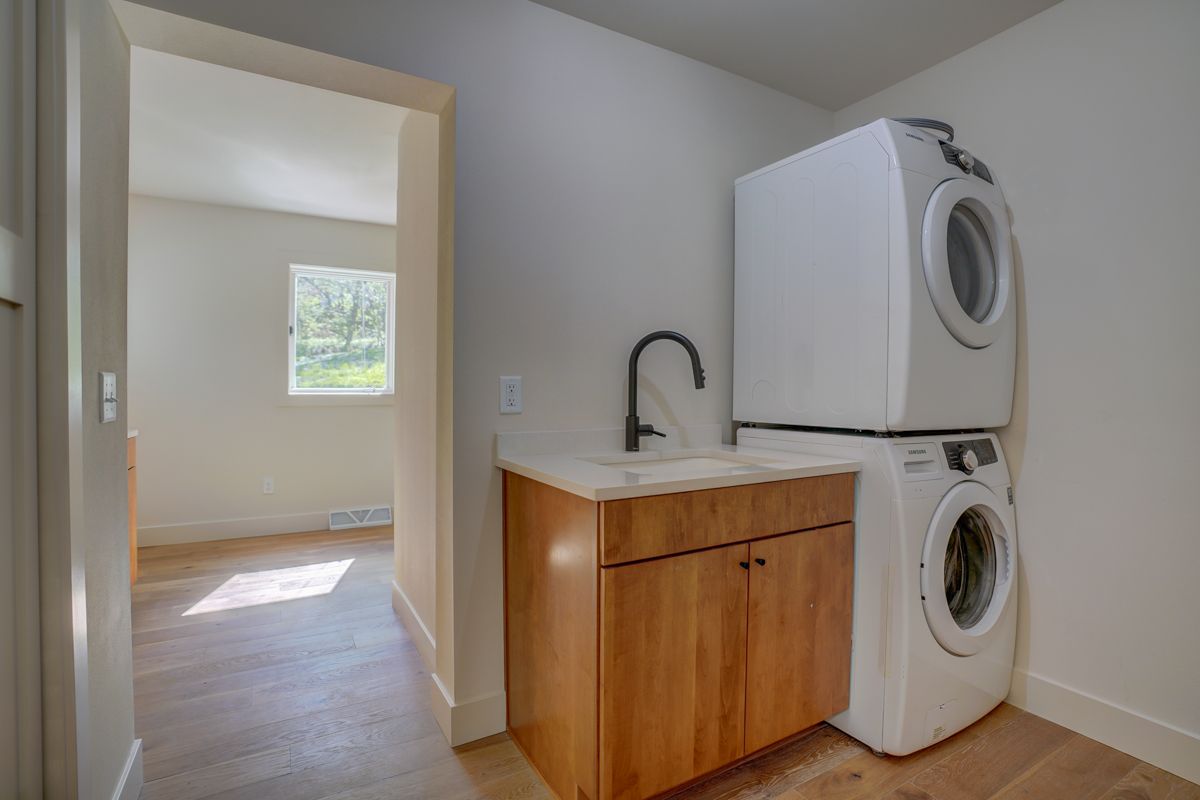 A laundry room with a washer and dryer stacked on top of each other.