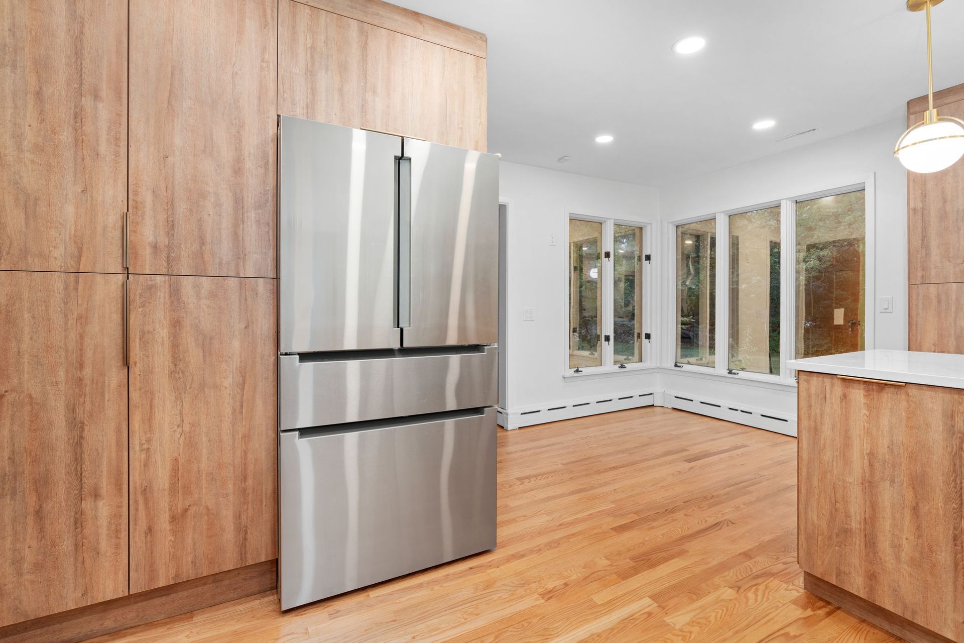 A kitchen with wooden cabinets and a stainless steel refrigerator.