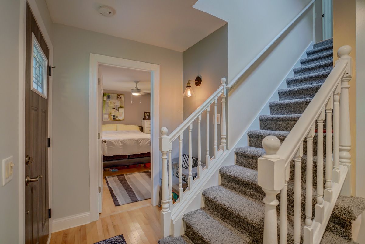 A hallway with stairs leading up to the second floor of a house.