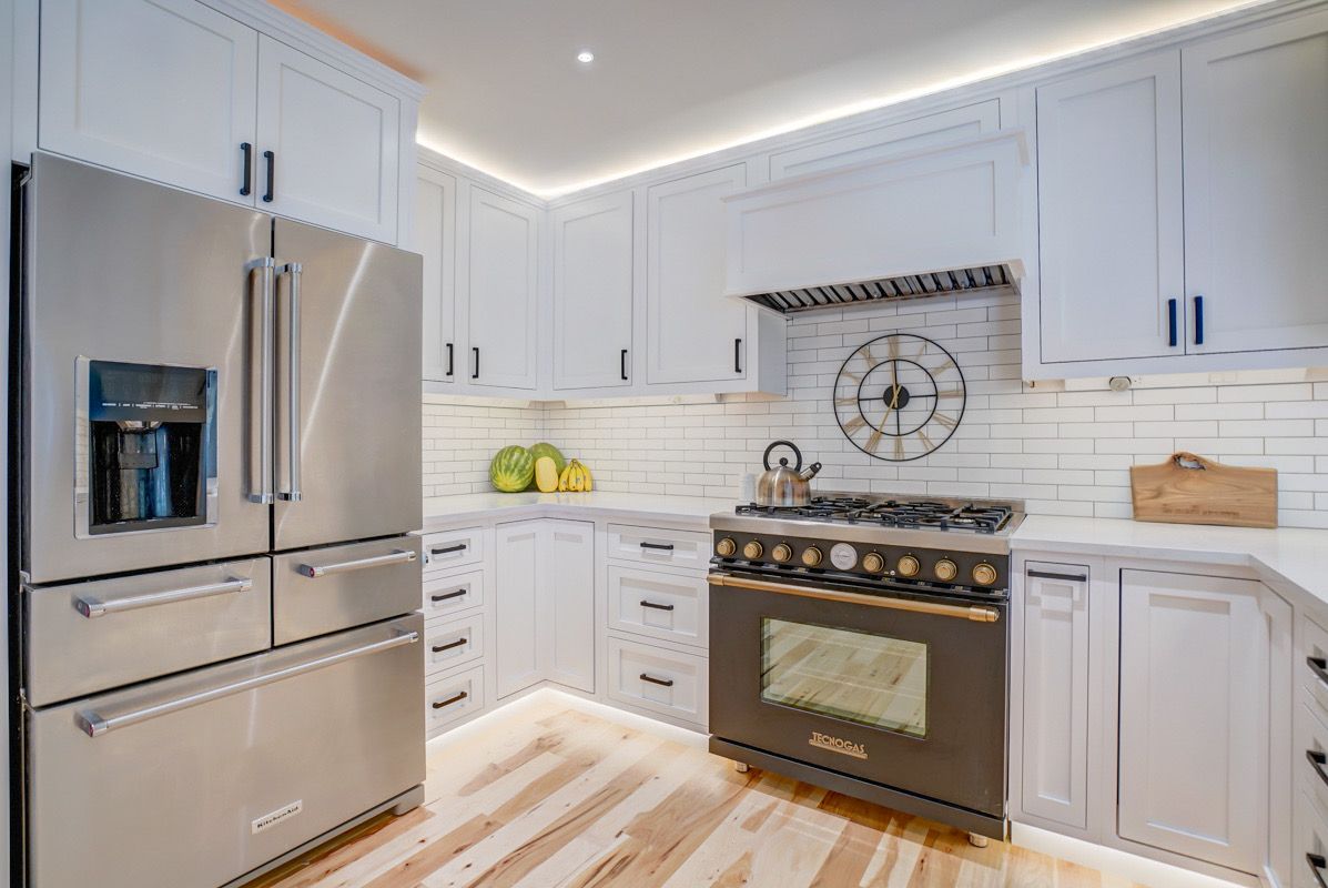 A kitchen with stainless steel appliances and white cabinets.