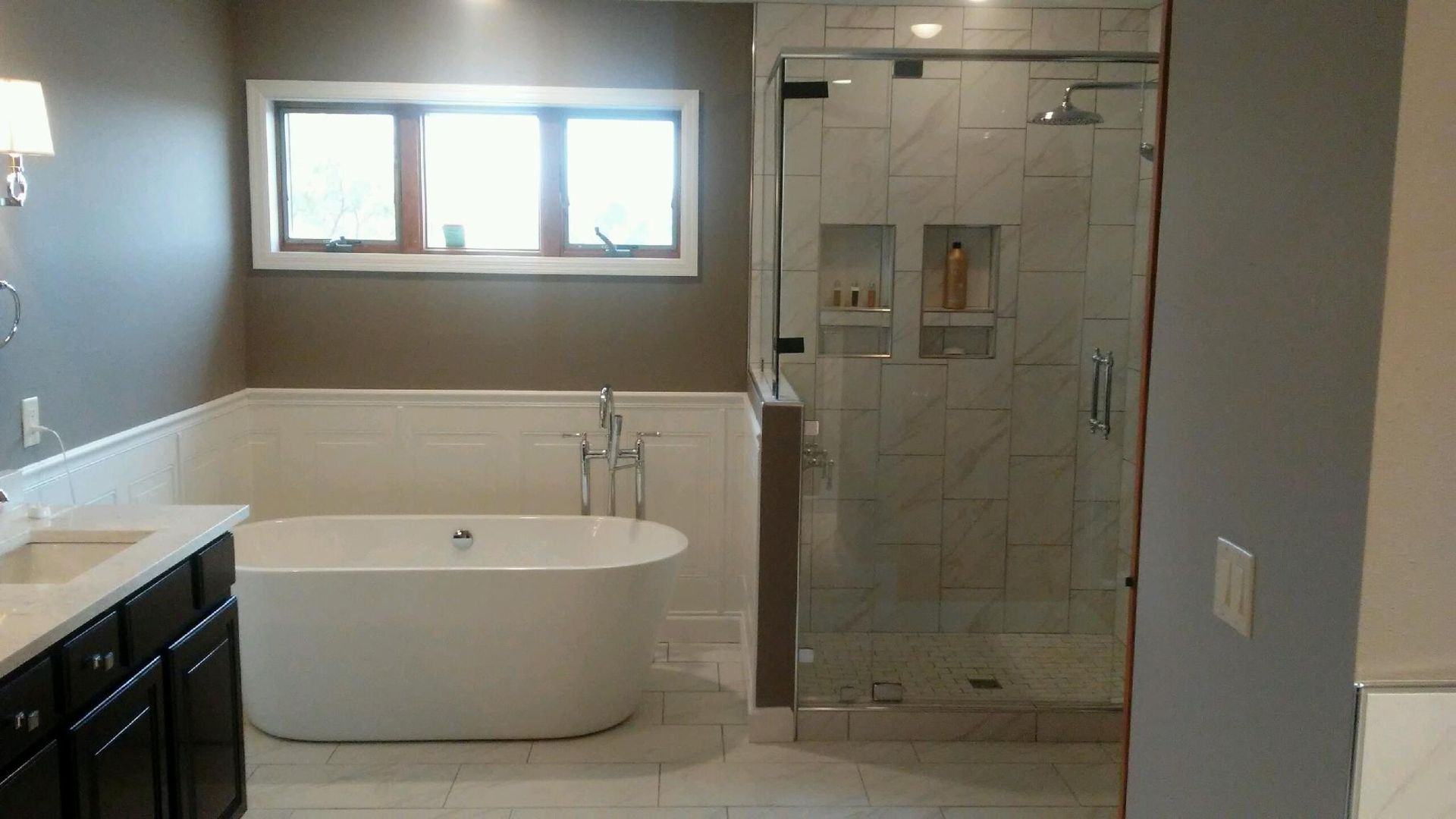 A bathroom with a tub , sink , and shower.