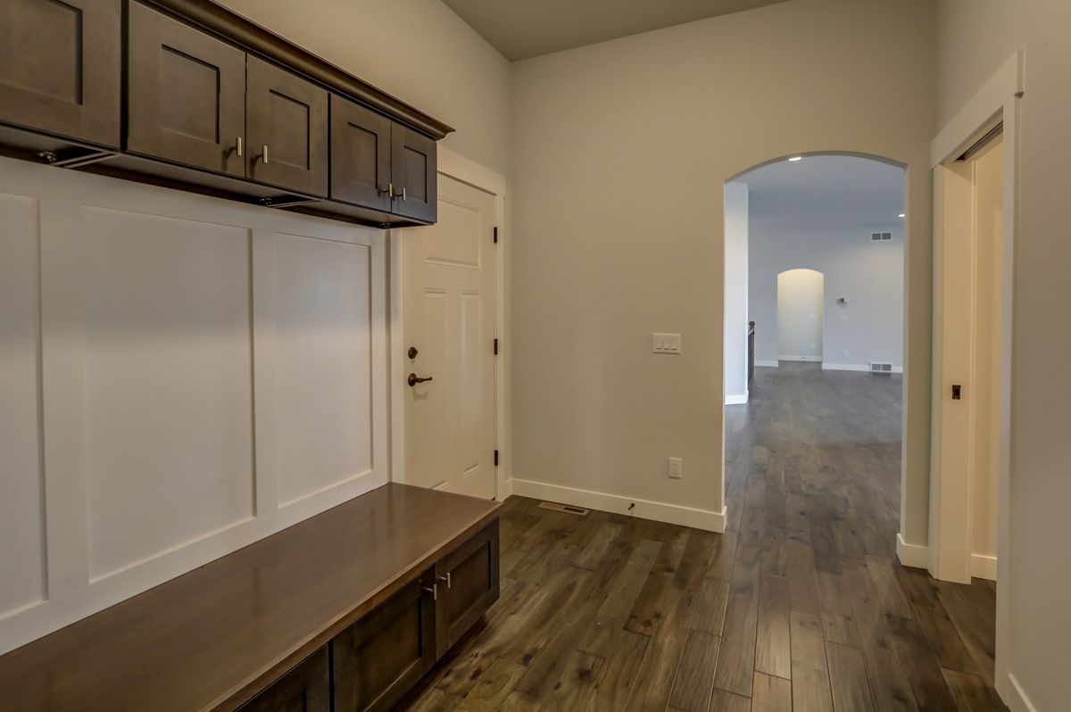 A hallway with a bench and cabinets in a house.