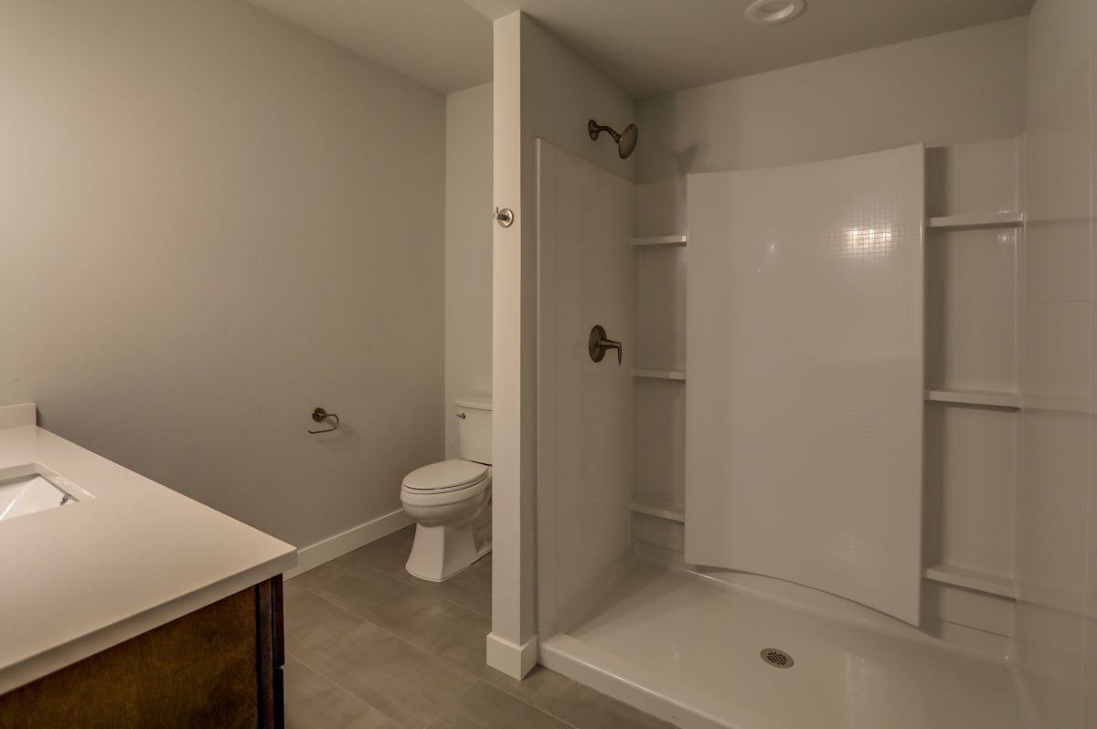 A bathroom with a toilet , sink and shower.