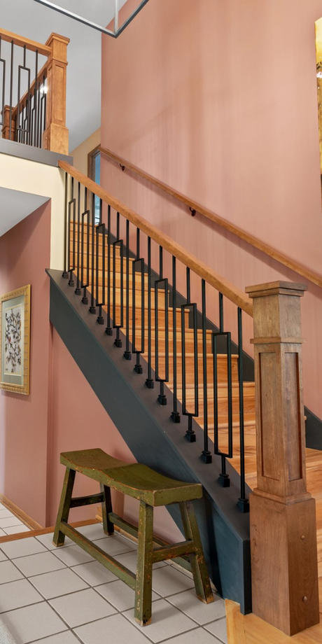 A staircase with a wooden bench underneath it