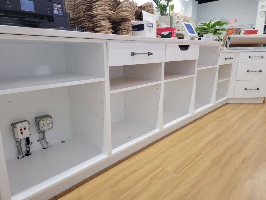 A row of empty shelves in a store with a wooden floor.