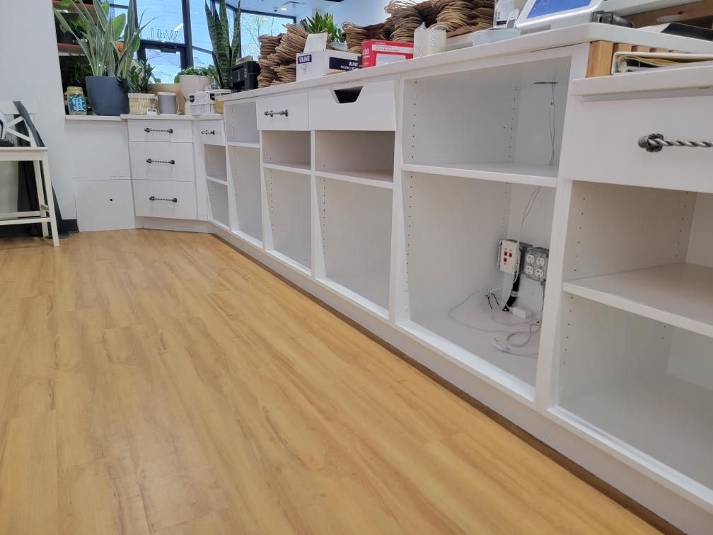 A long row of shelves and drawers in a room with wooden floors.