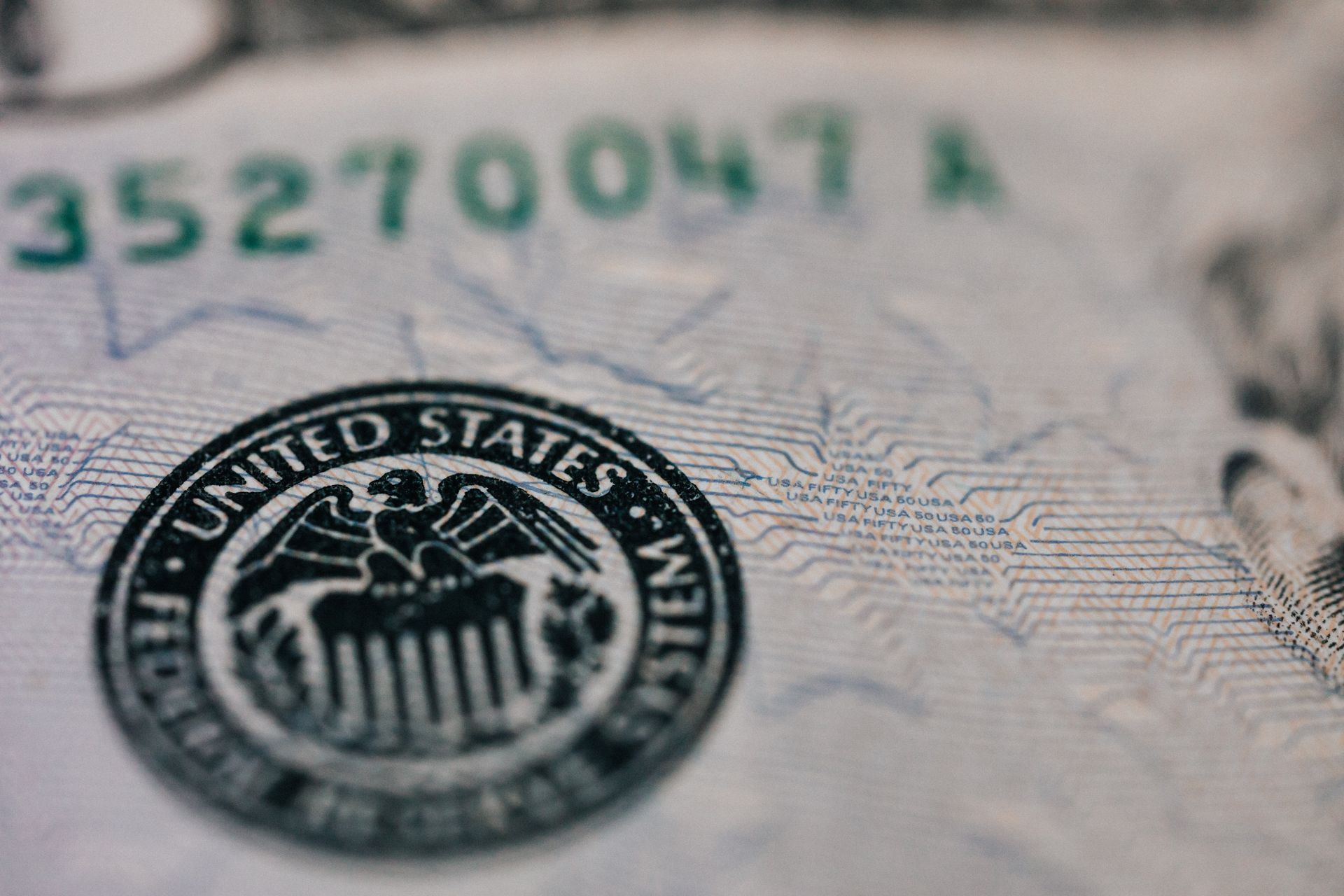 Close-up of U.S. currency, showing the seal of the United States and a serial number.