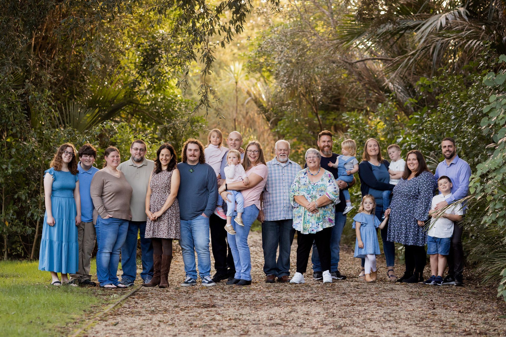 Extended family posing for a portrait in a garden at sunset
