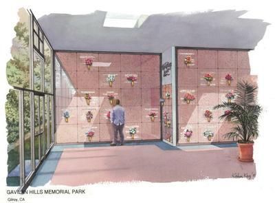 A person looks at a wall of columbarium niches with flowers. Indoor, sunny setting.