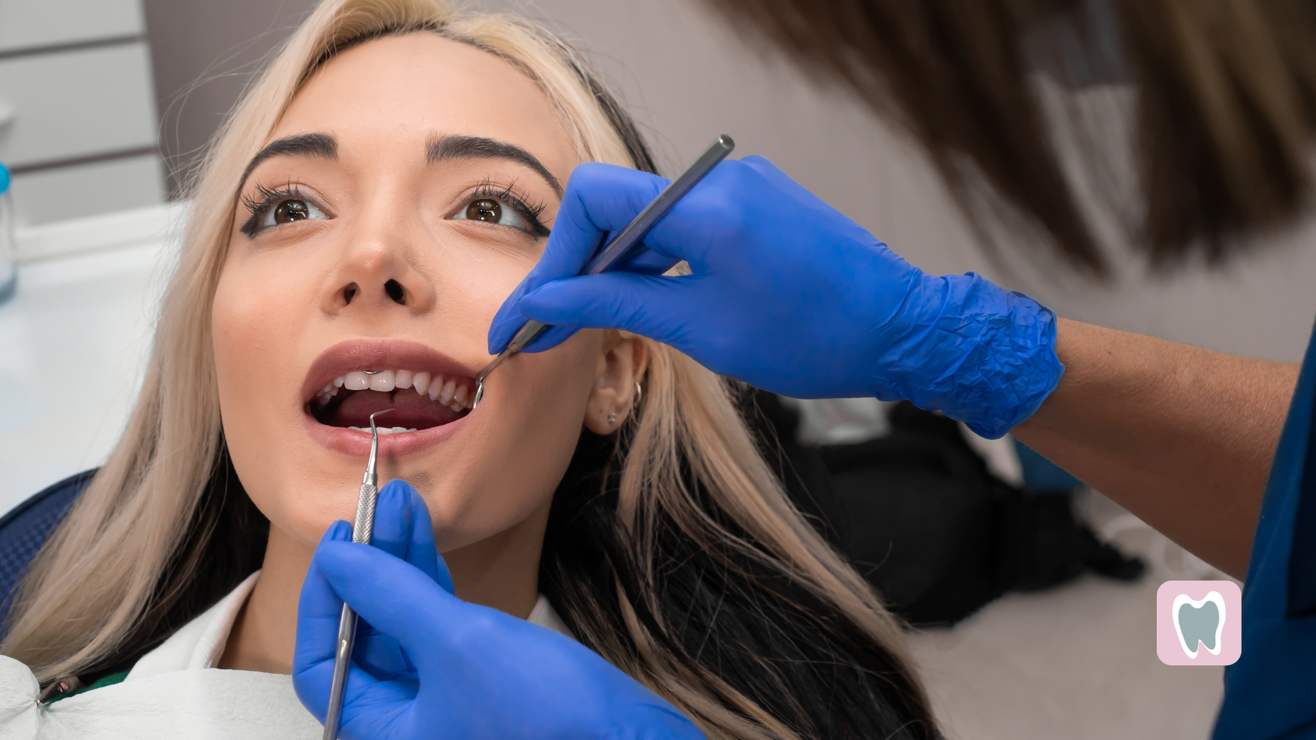 A woman is getting her teeth examined by a dentist.