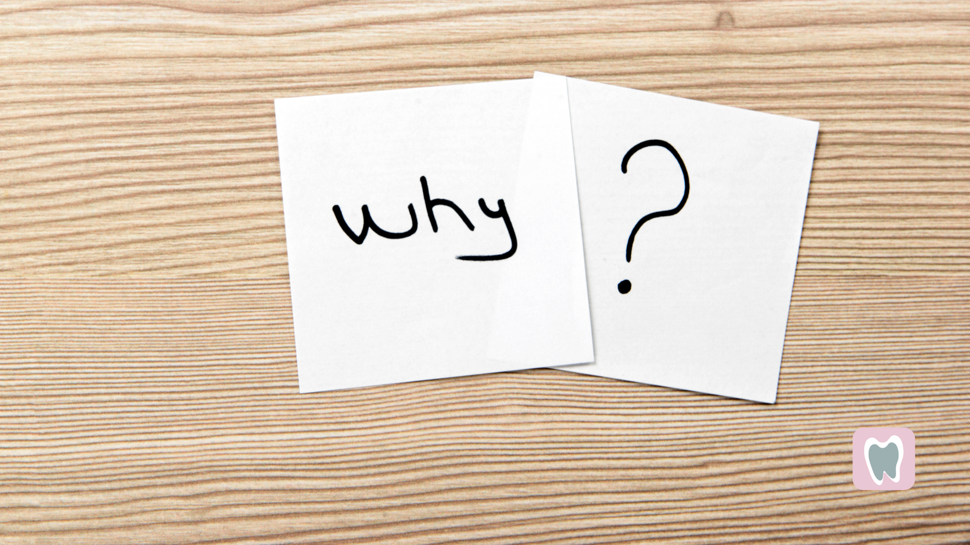 Two sticky notes on a wooden table that say why and a question mark