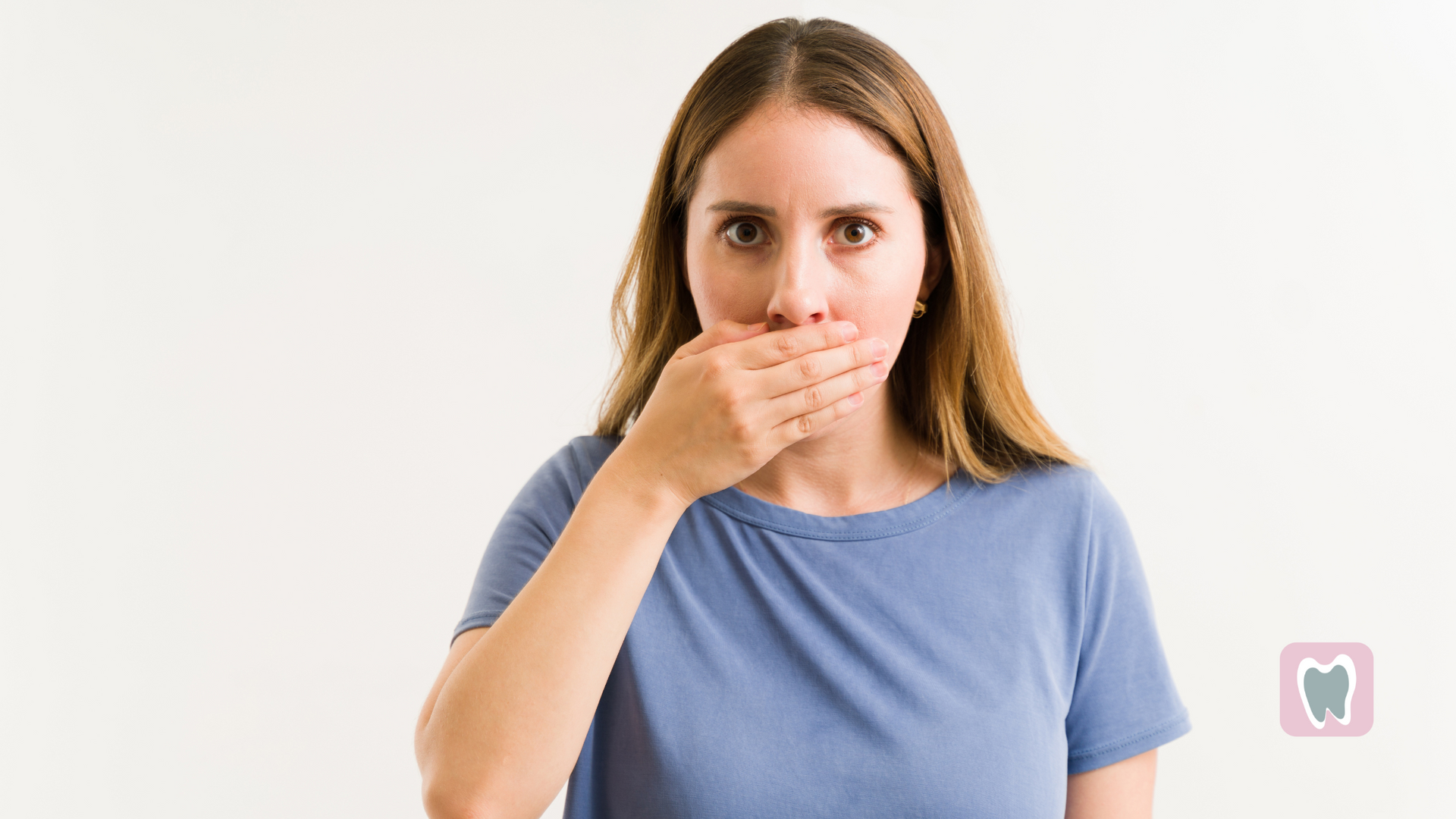 A woman is covering her mouth with her hand.