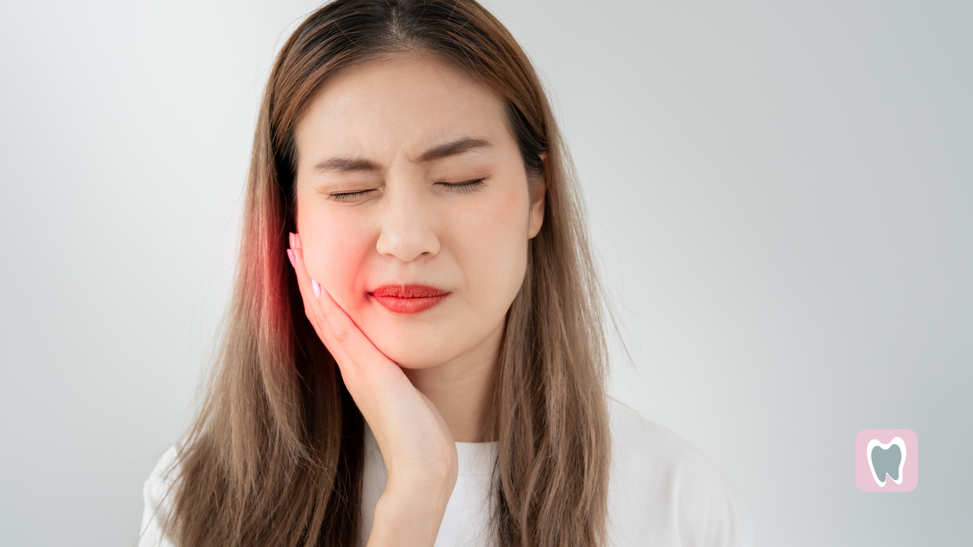 A woman is holding her face in pain because of a toothache.