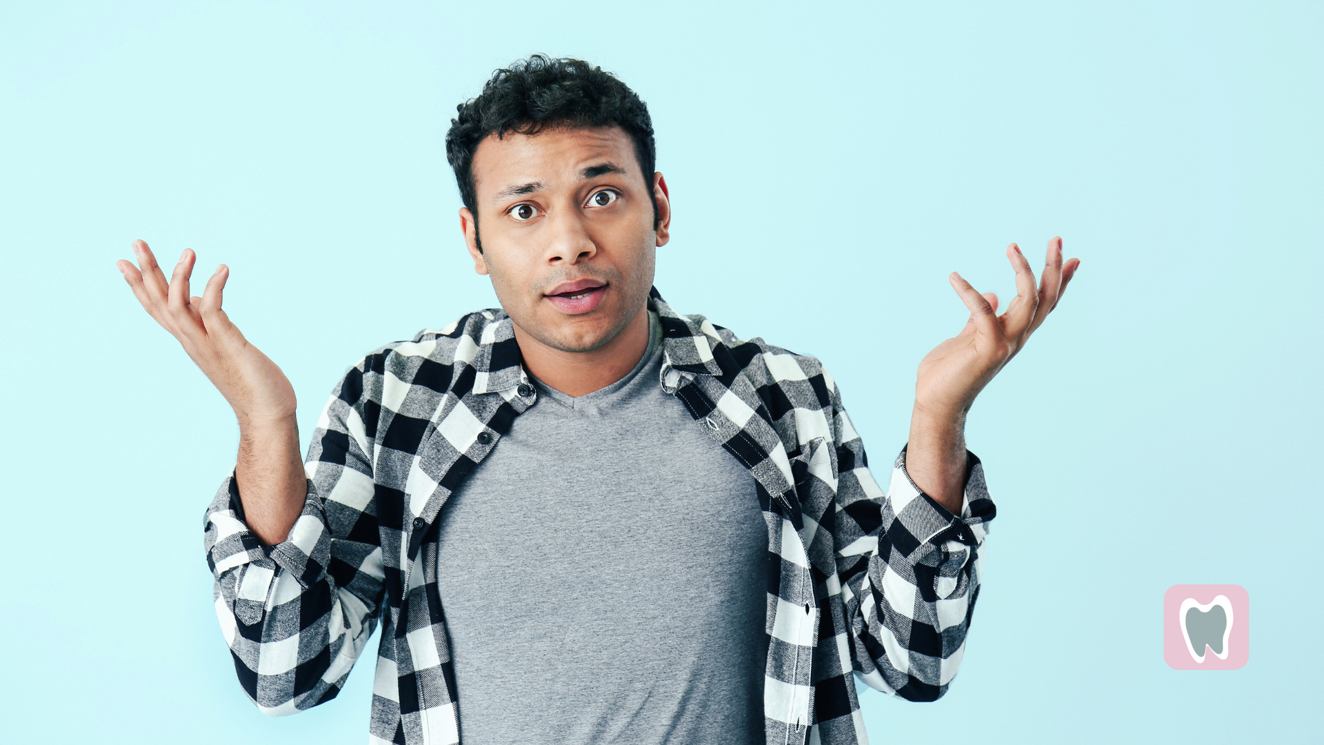 A man in a plaid shirt is shrugging his shoulders.