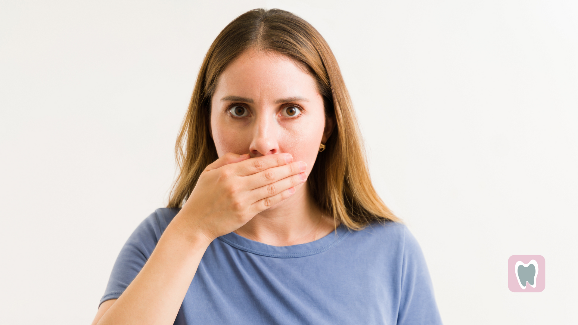 A woman is covering her mouth with her hand.