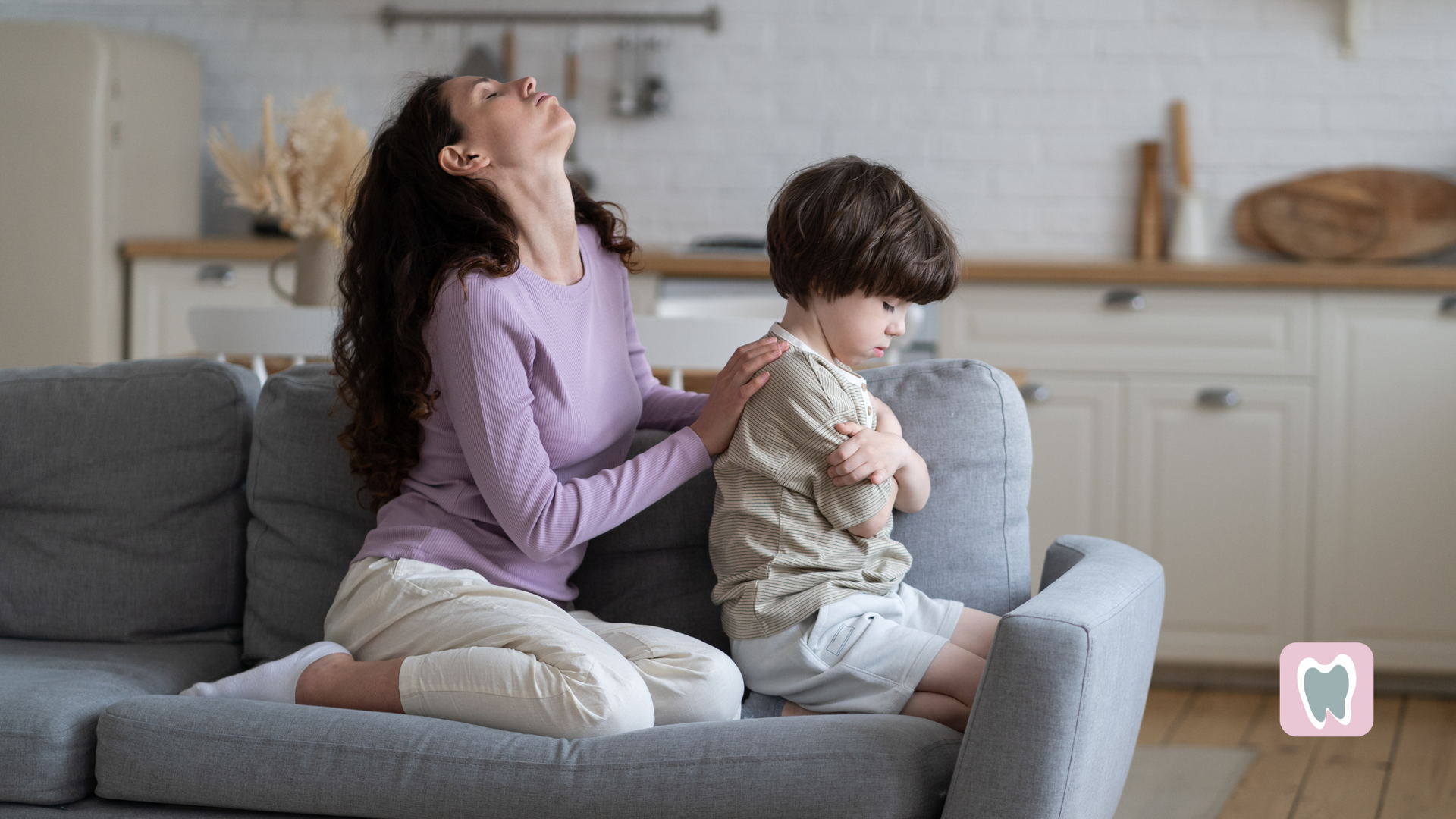 A woman is sitting on a couch with a child.
