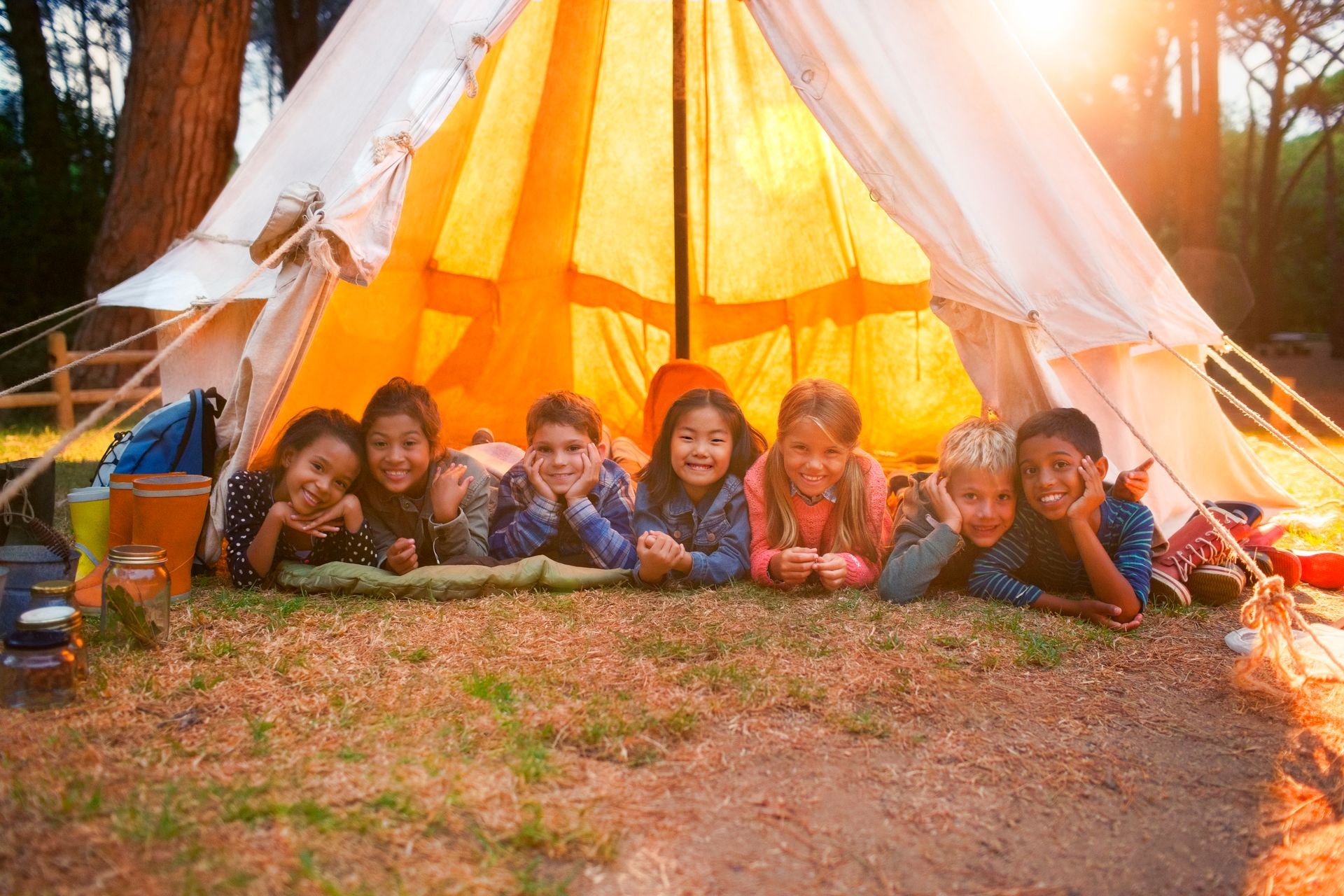 A group of children are laying in a tent.