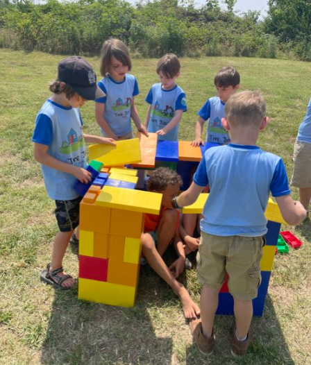 A group of children are playing with blocks in a field