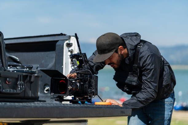 A man is working on a camera in the back of a truck.