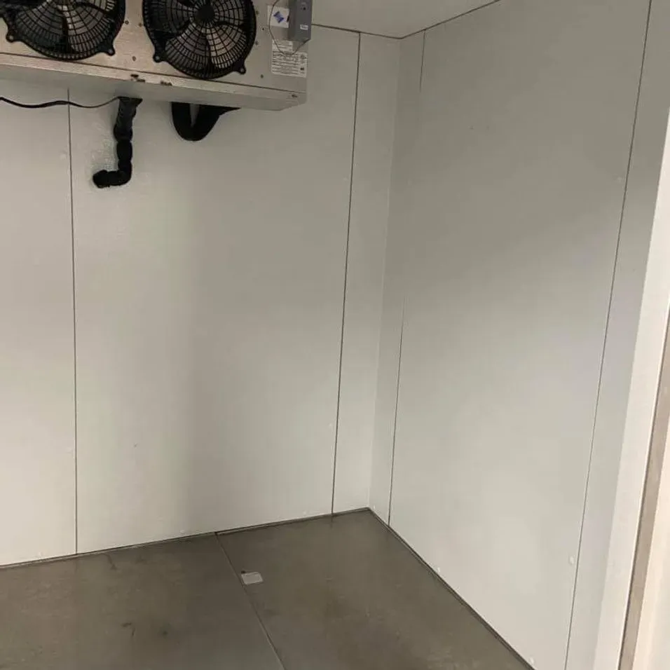 A room with white walls and a fan on the wall.