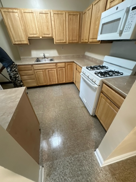 A kitchen with wooden cabinets and a white stove
