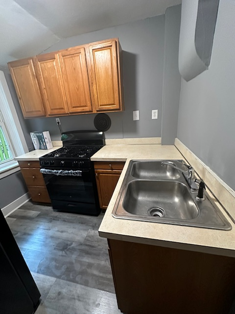 A kitchen with a sink , stove , and cabinets.