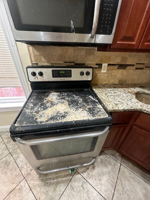 A kitchen with a stove top oven and a microwave