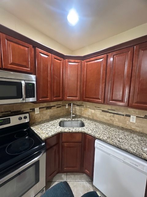 A kitchen with wooden cabinets and granite counter tops