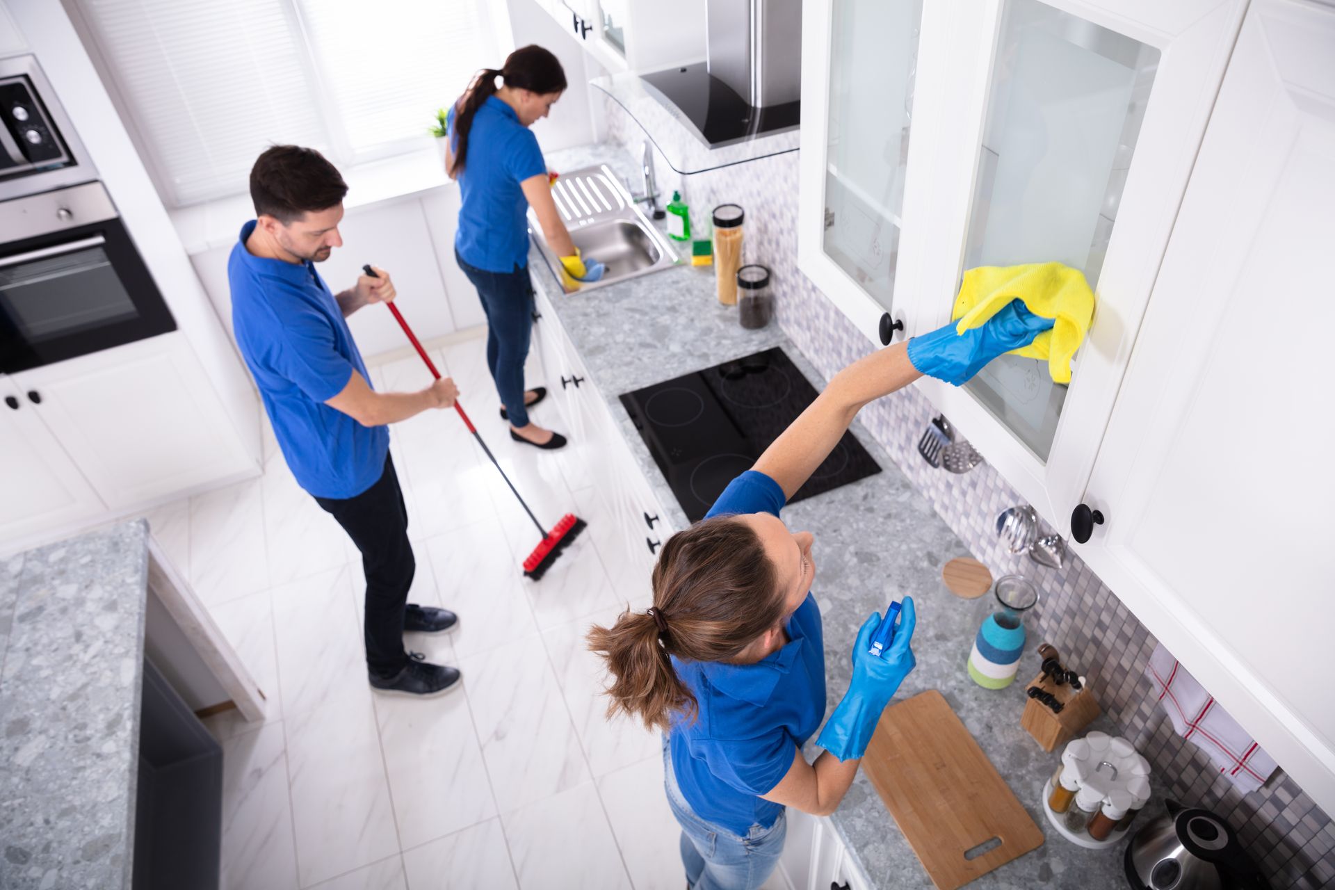 A group of people are cleaning a kitchen.