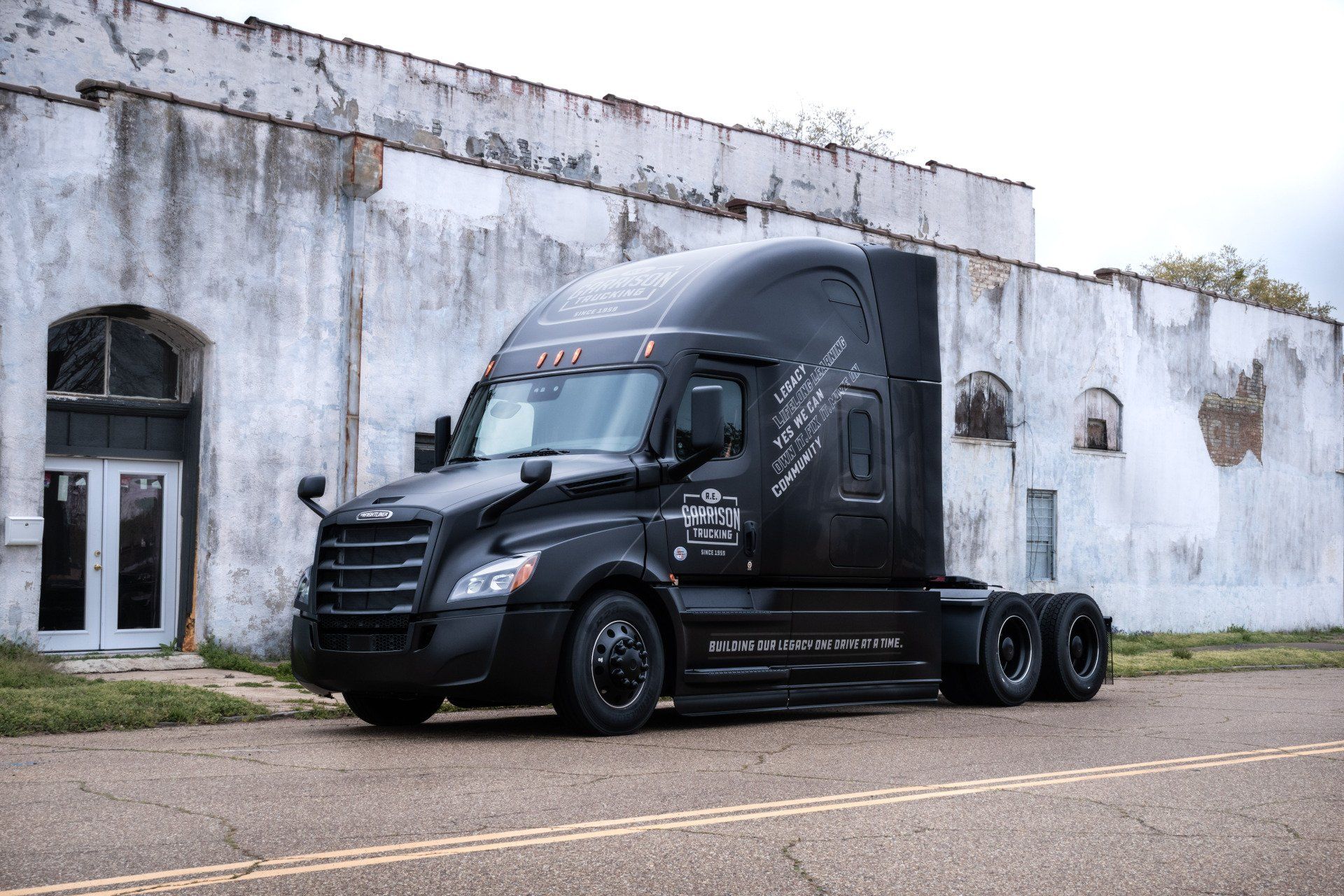 Black big Rig in front of white old building
