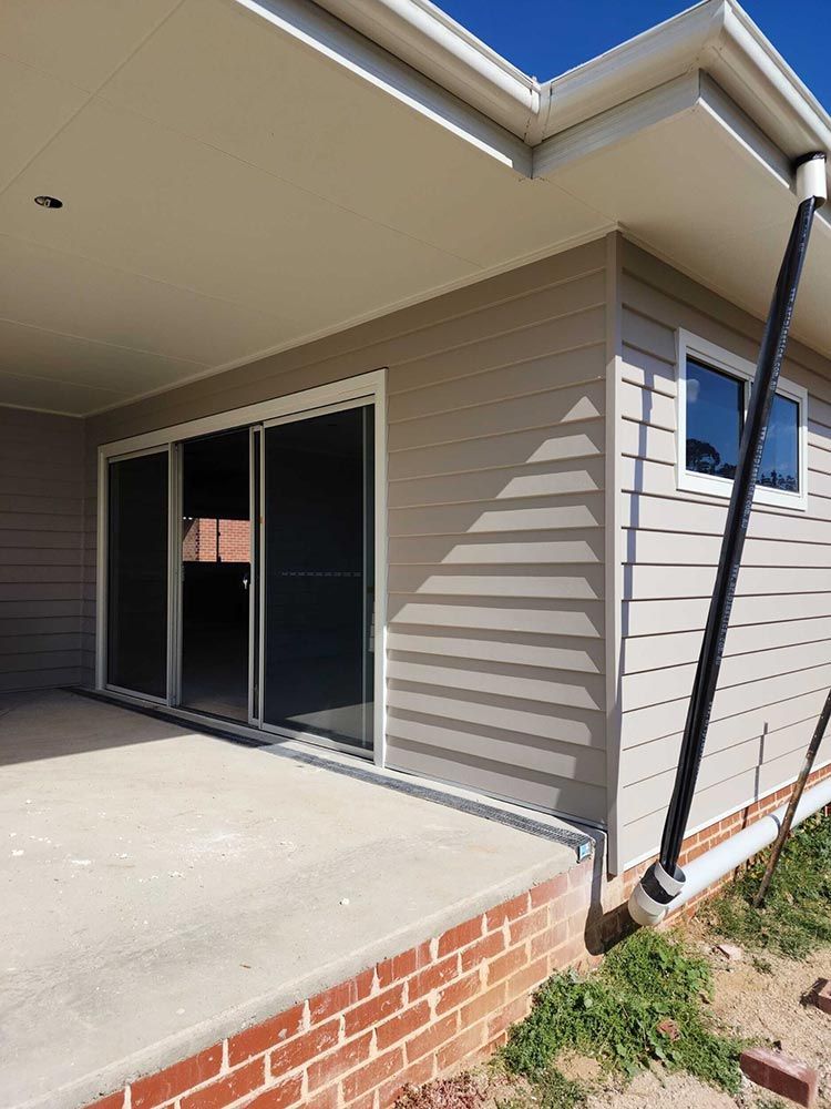 A House With Sliding Glass Doors And A Brick Foundation — Chandolin Construction In Robin Hill, NSW