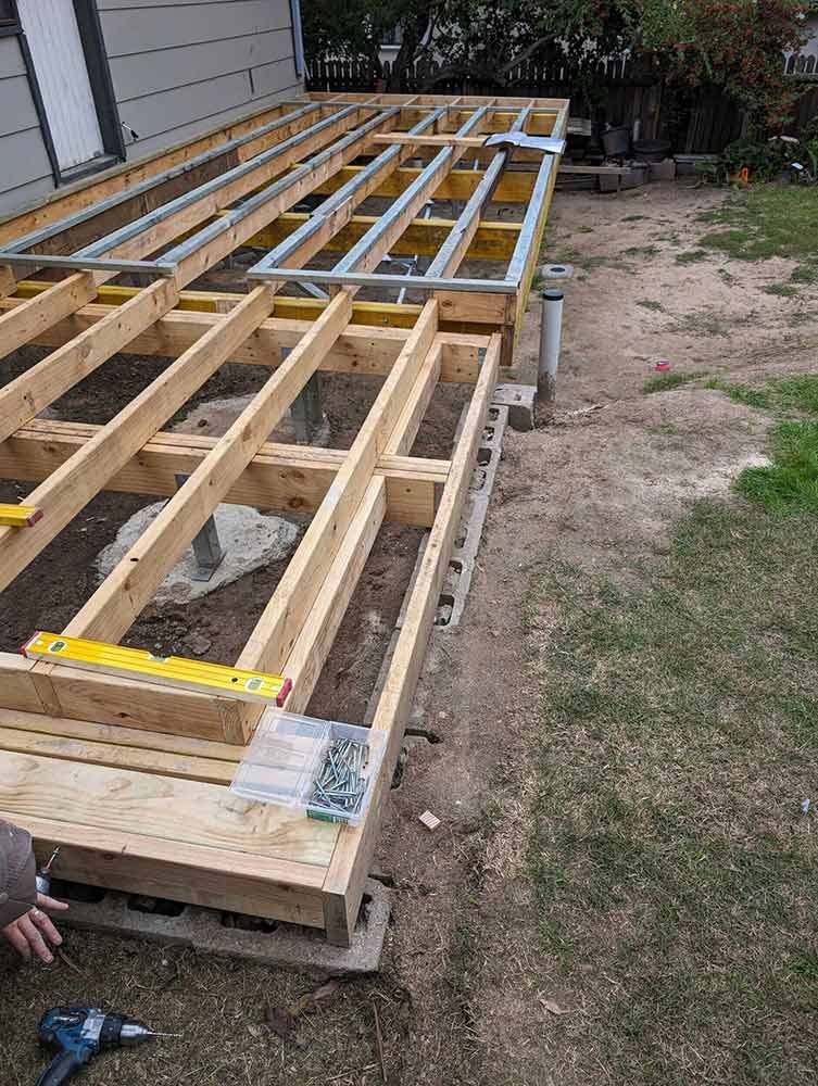 A Wooden Deck Is Being Built In The Backyard Of A House — Chandolin Construction In Robin Hill, NSW