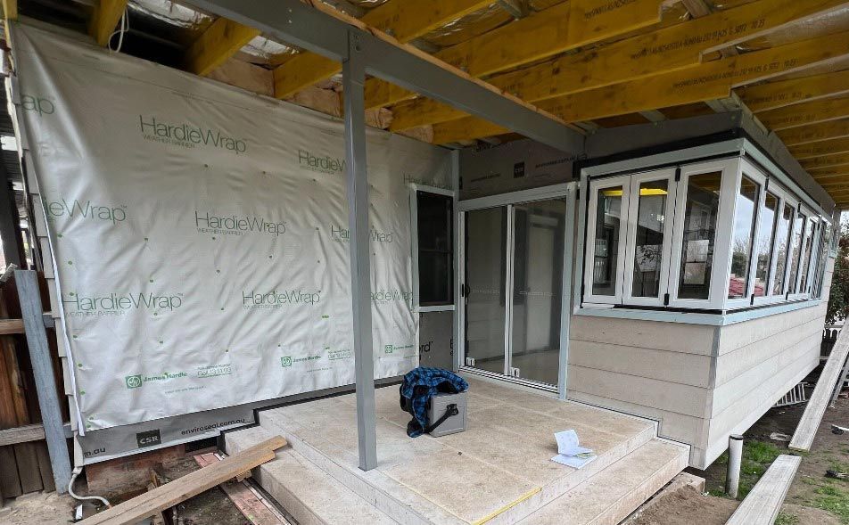 A House Is Being Built With A Lot Of Windows And A Covered Porch — Chandolin Construction In Robin Hill, NSW