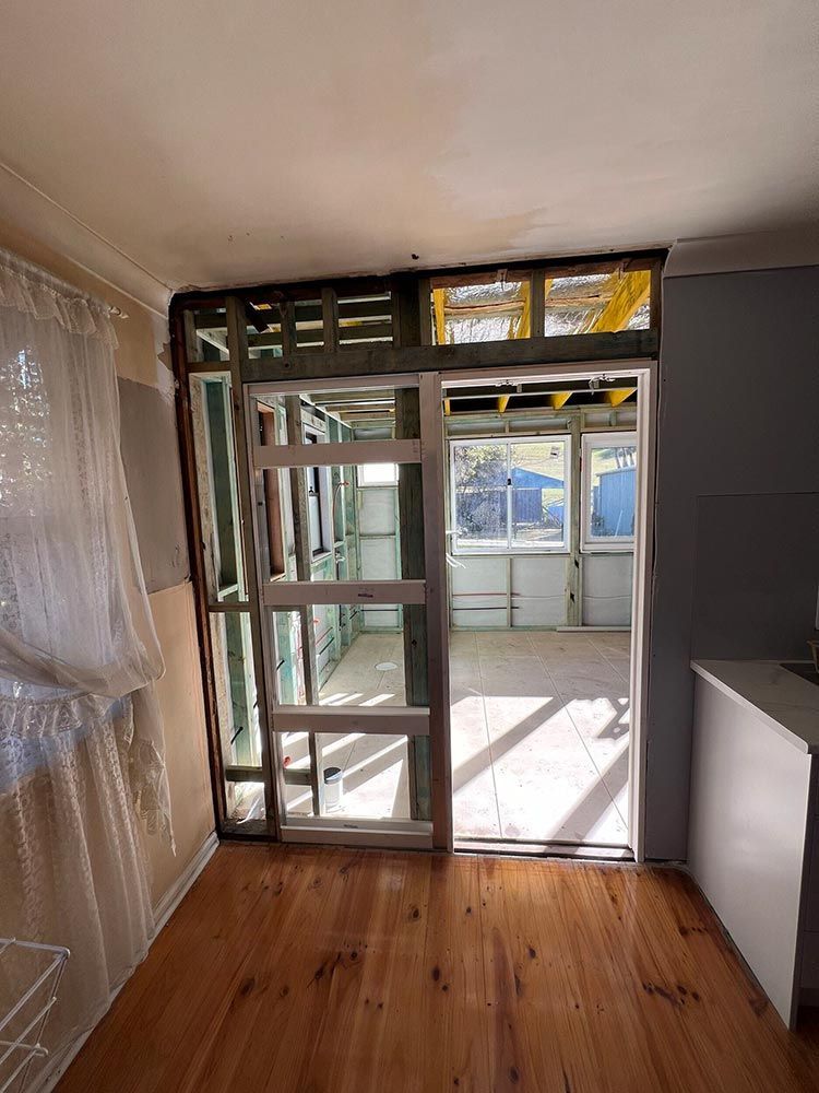 An Empty Room With Wooden Floors And A Sliding Glass Door — Chandolin Construction In Robin Hill, NSW