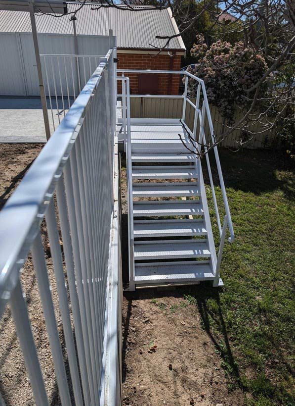 A Set Of Stairs Leading Up To A House With A White Railing — Chandolin Construction In Robin Hill, NSW