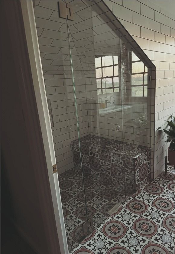 A Bathroom With A Glass Shower Door And A Tiled Floor — Chandolin Construction In Robin Hill, NSW