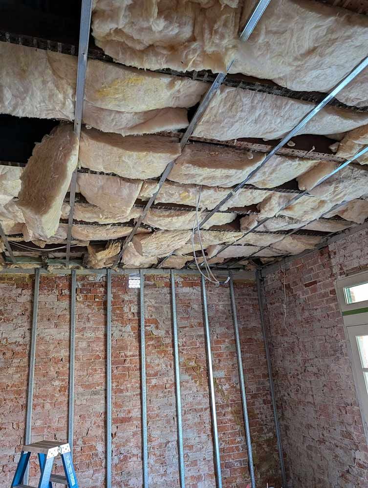 A Room With A Ladder And A Lot Of Insulation On The Ceiling — Chandolin Construction In Robin Hill, NSW