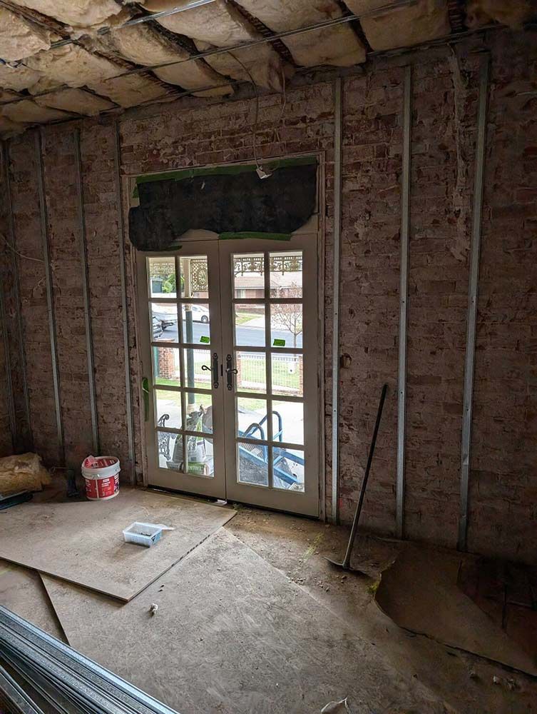 A Room With A Brick Wall And A French Door — Chandolin Construction In Robin Hill, NSW