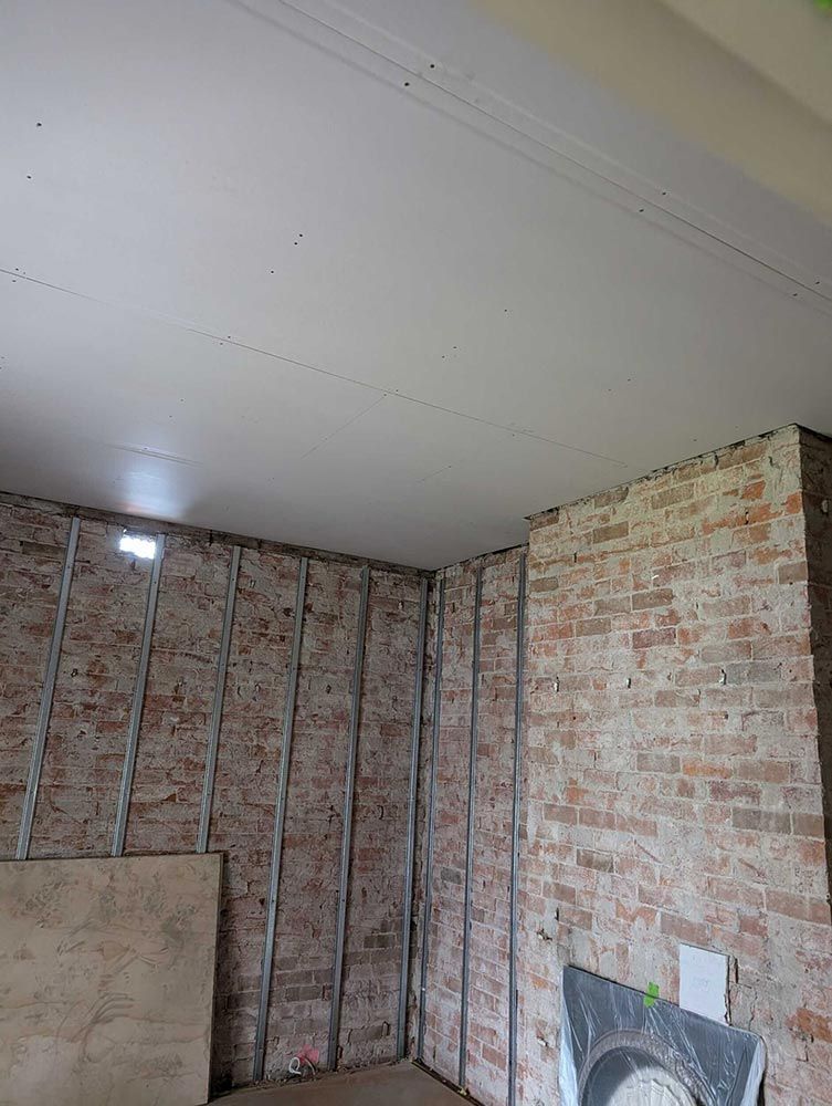 A Room With Brick Walls And A White Ceiling — Chandolin Construction In Robin Hill, NSW