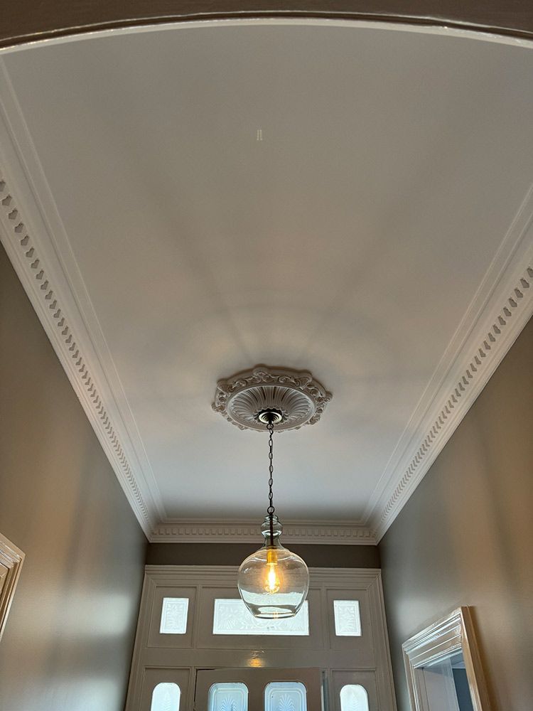 A Light Fixture Is Hanging From The Ceiling Of A Hallway — Chandolin Construction In Robin Hill, NSW