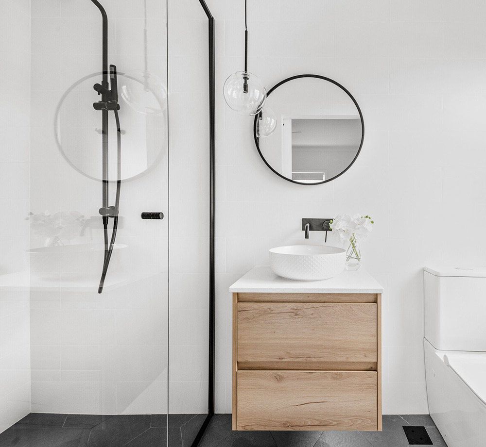 A Bathroom With A Sink, Mirror And Shower — Chandolin Construction In Robin Hill, NSW