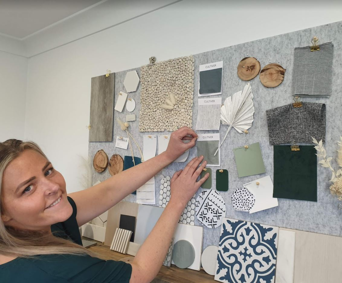 A Woman Is Standing In Front Of A Wall With A Bunch Of Samples On It — Chandolin Construction In Robin Hill, NSW