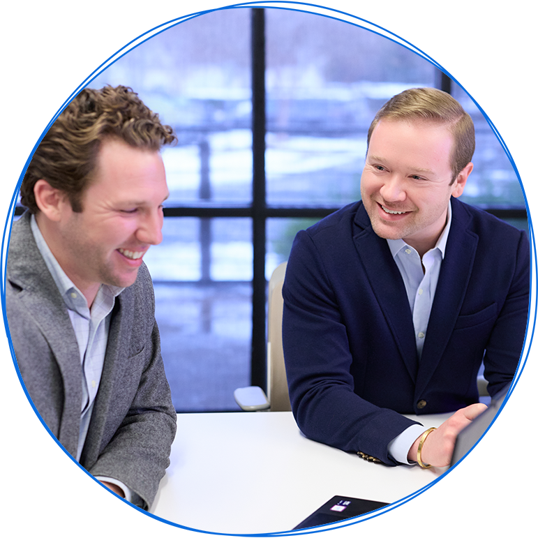 People in a business meeting around a table, using laptops and discussing ideas. Blue and white colors.
