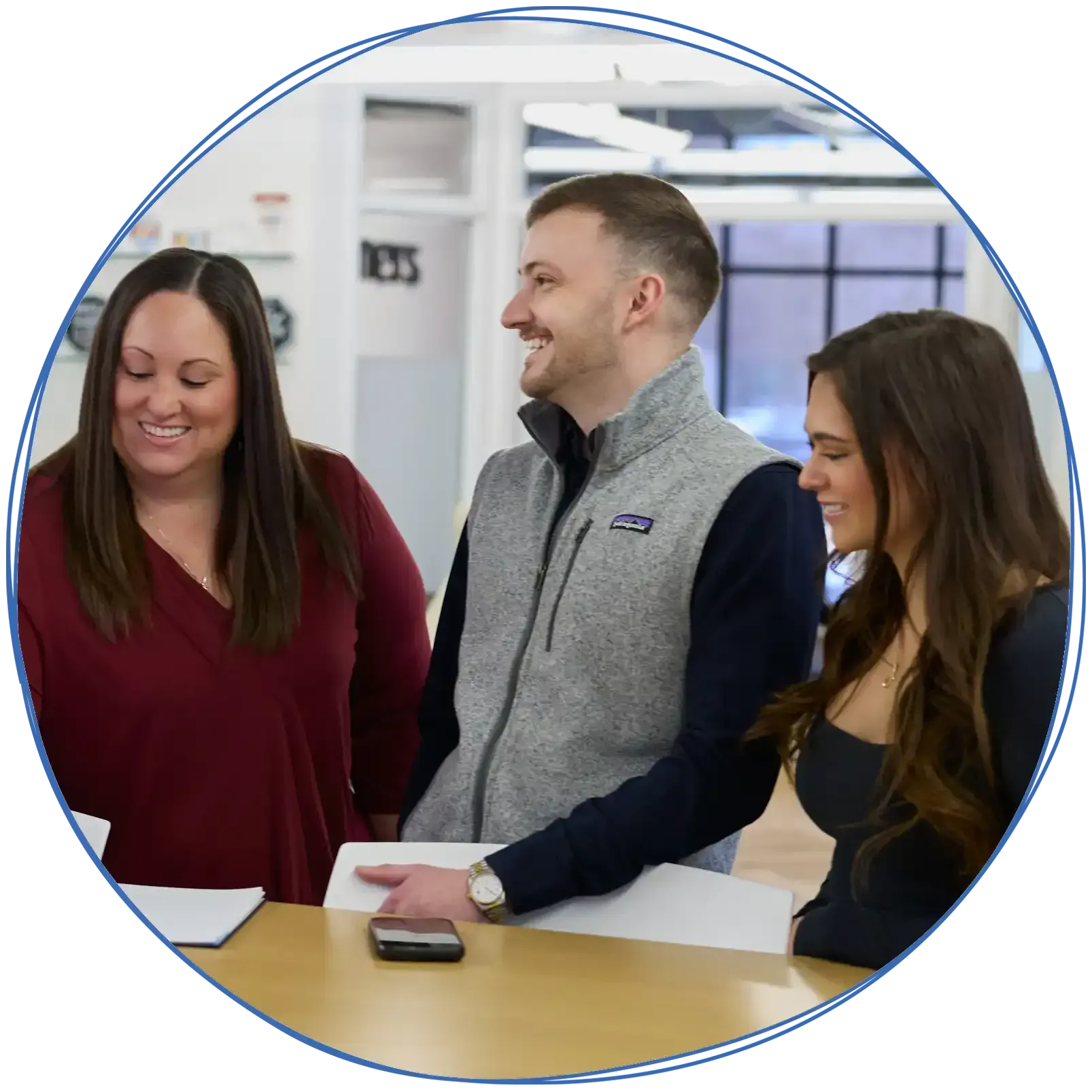 People in a business meeting around a table, using laptops and discussing ideas. Blue and white colors.