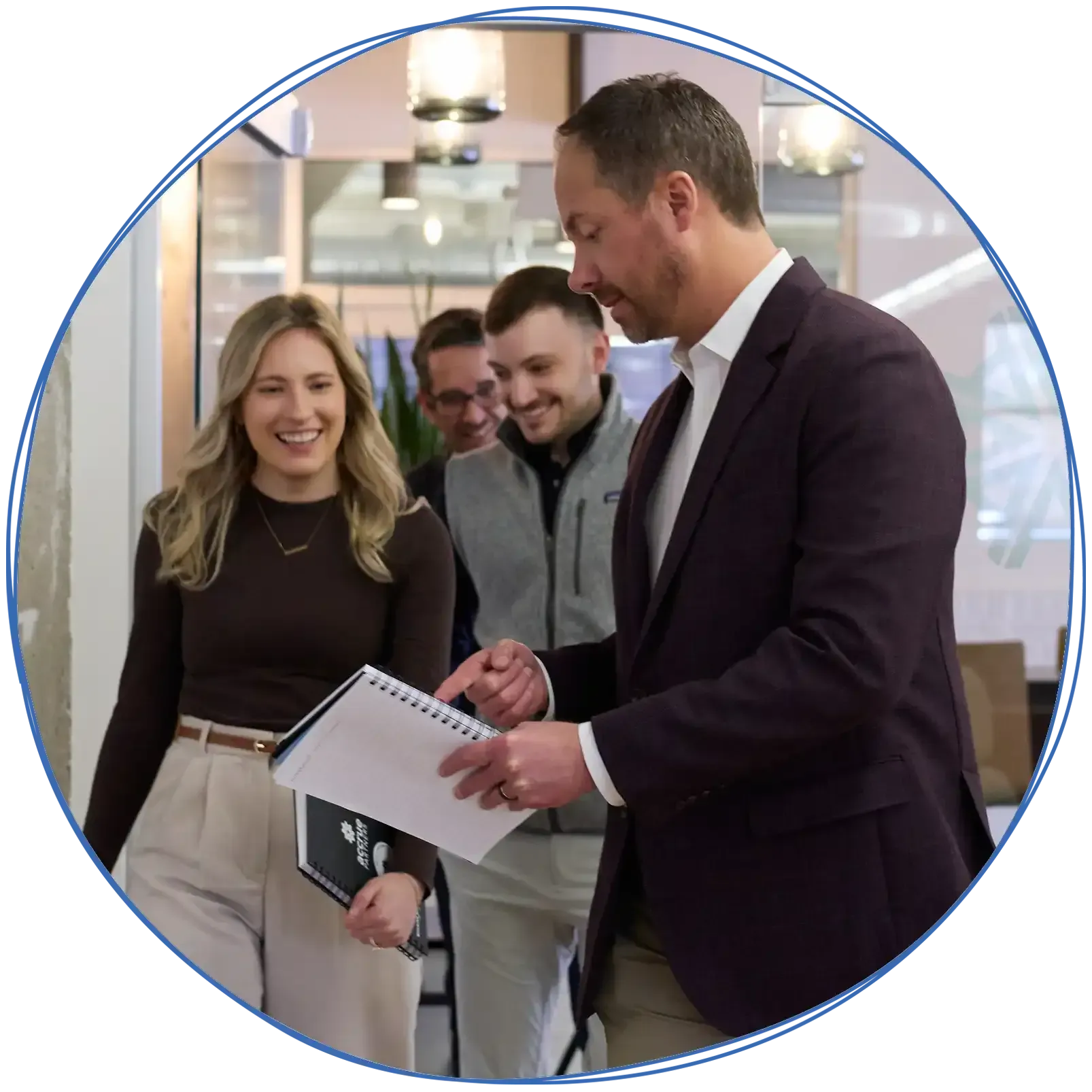 People in a business meeting around a table, using laptops and discussing ideas. Blue and white colors.
