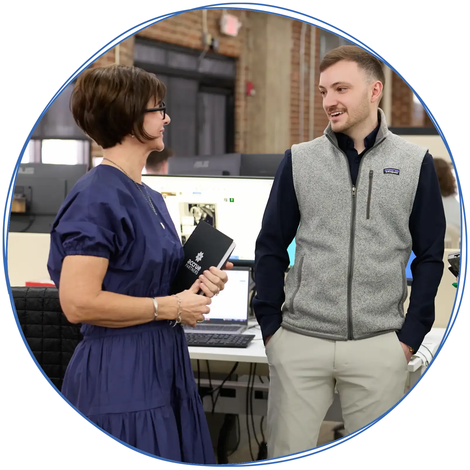 People in a business meeting around a table, using laptops and discussing ideas. Blue and white colors.